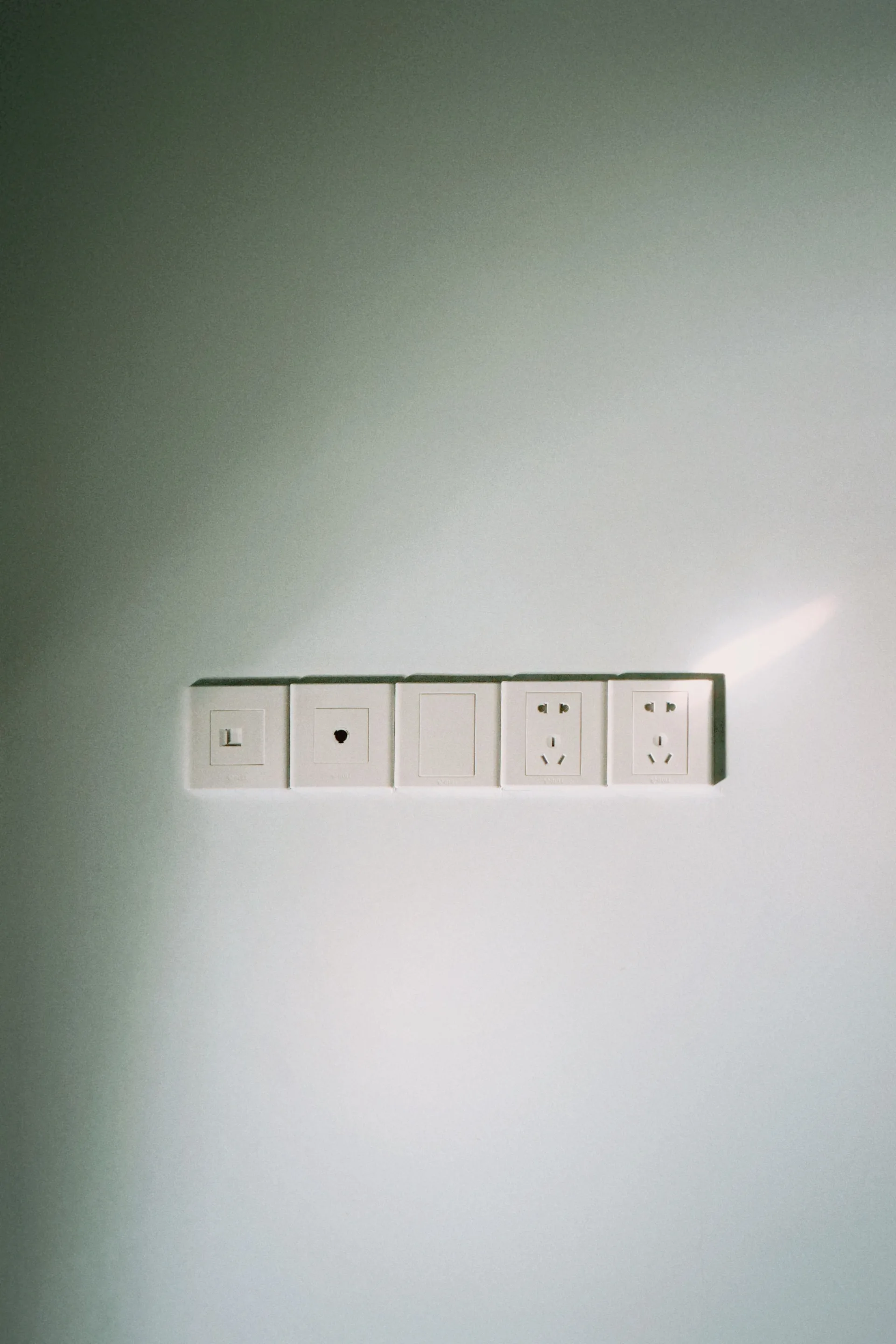 A row of wall outlets in a plain interior