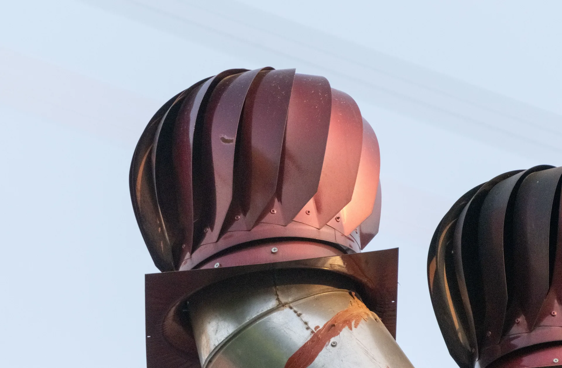 A rotating roof turbine ventilator against a clear sky