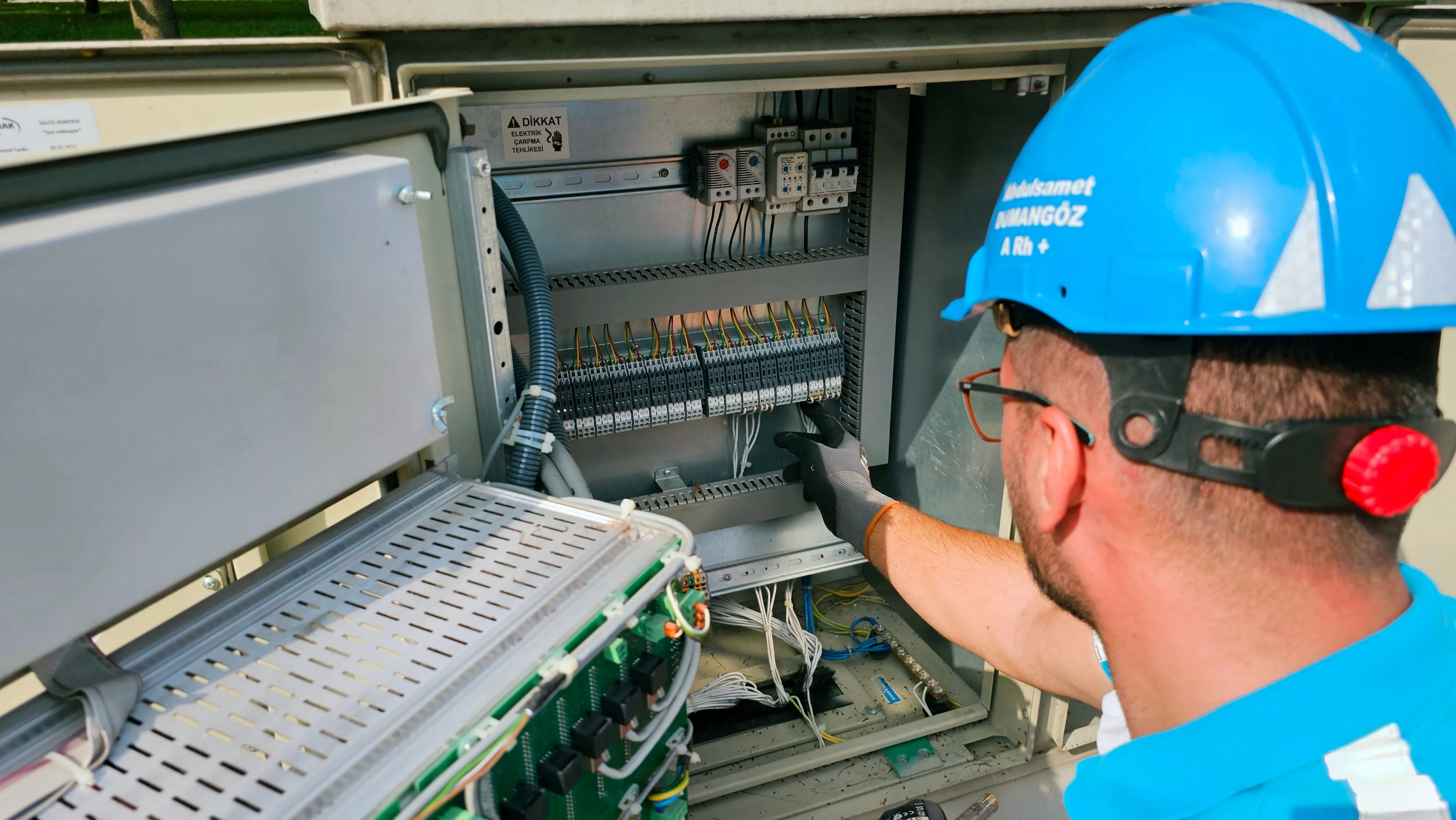 An electrician working on an outdoor fuse box
