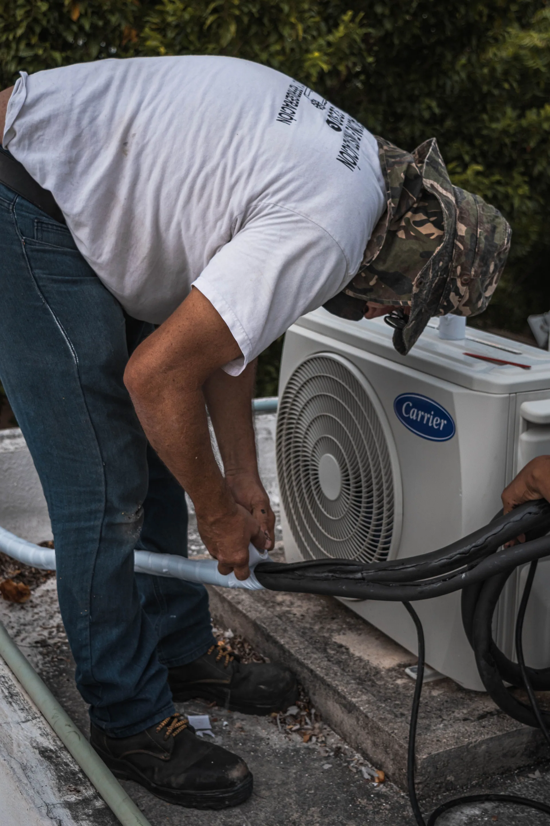 A technician working on an outdoor air conditioning unit