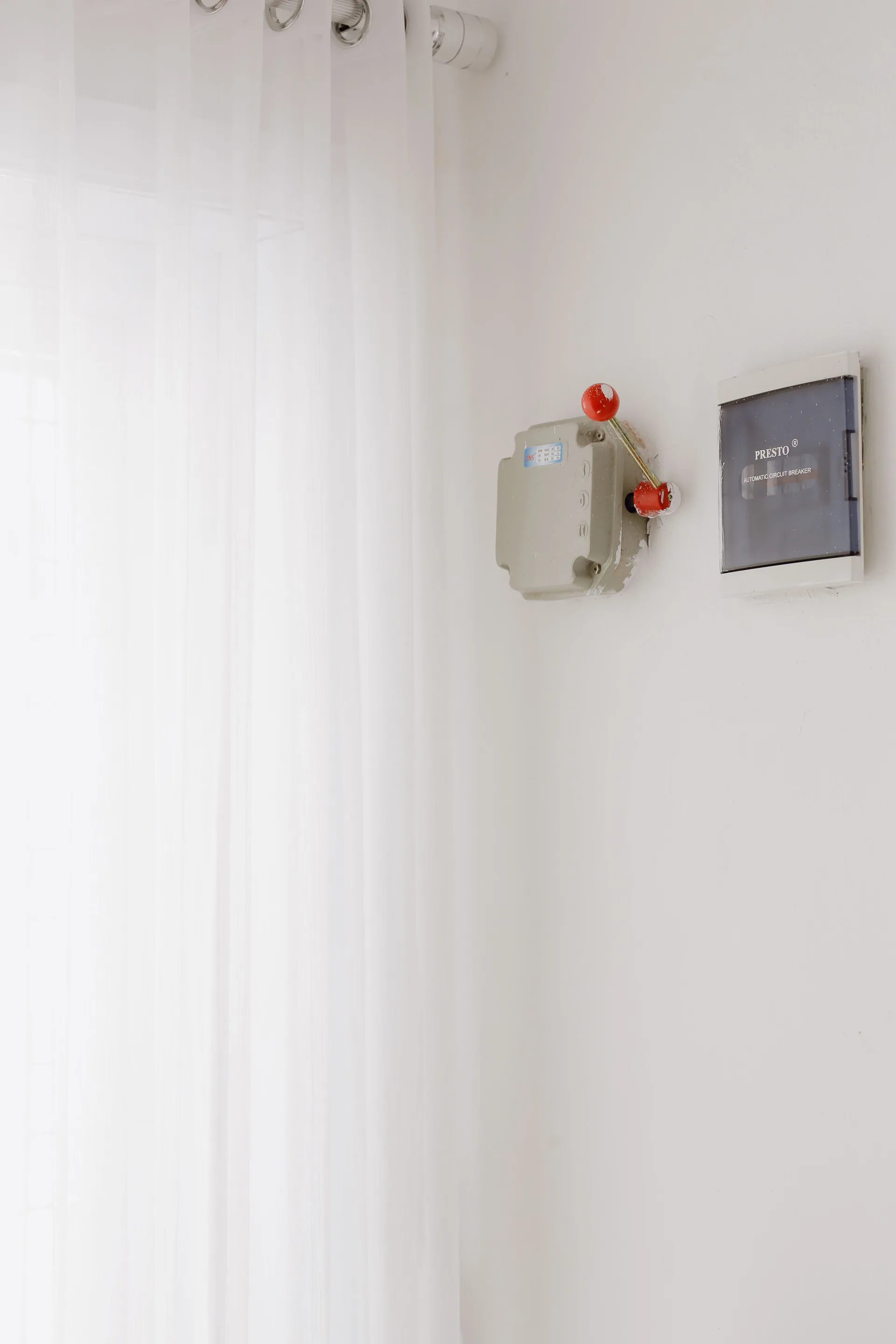 A circuit breaker panel mounted on a white indoor wall