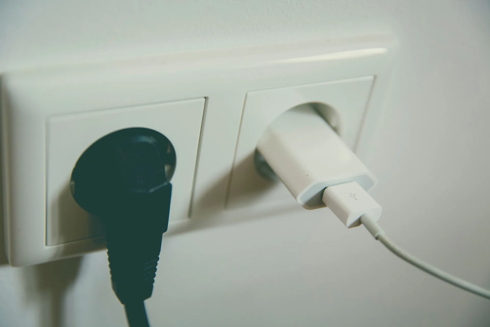 A wall outlet with two plugs inserted