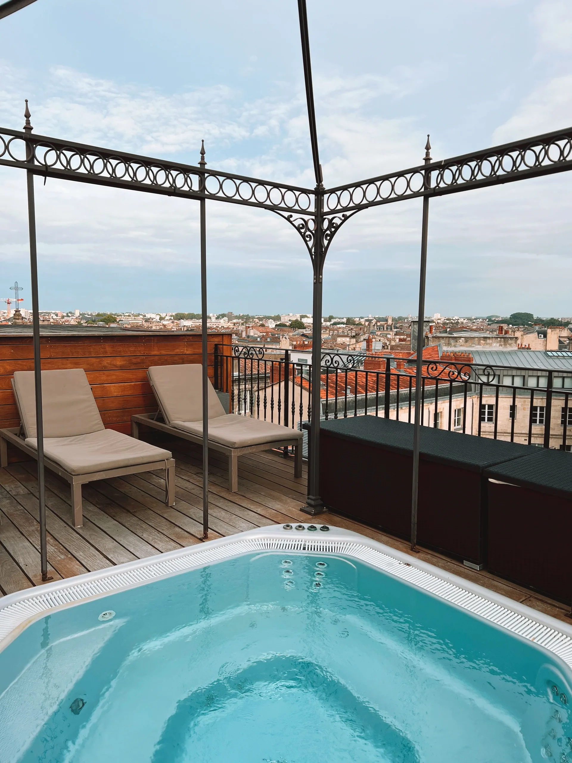 A hot tub on a rooftop terrace overlooking a city skyline