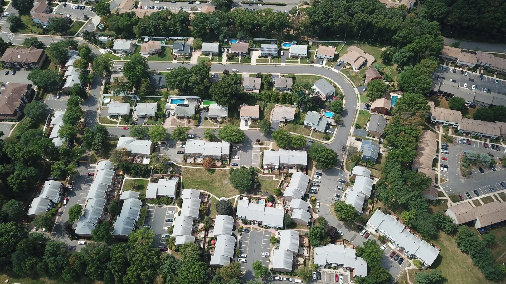 Aerial view of a suburban neighborhood with houses and tree-lined streets
