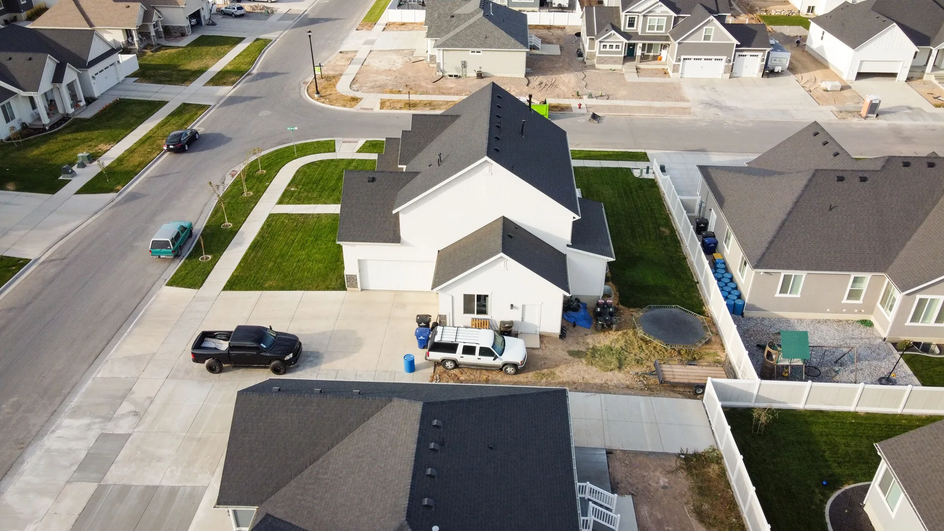 Aerial view of a suburban neighborhood with houses and vehicles parked on driveways