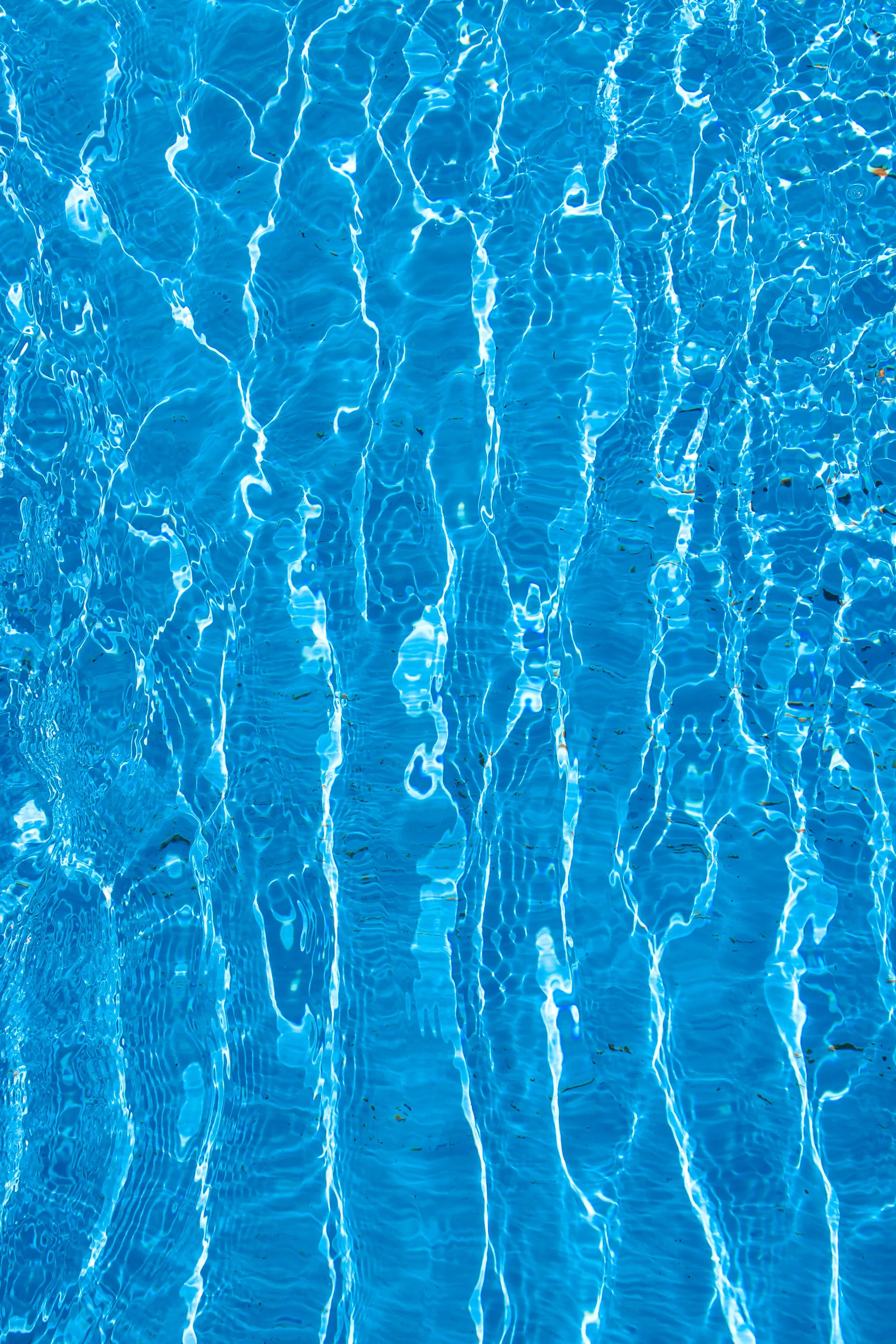 Close-up of bright blue swimming pool water with ripples