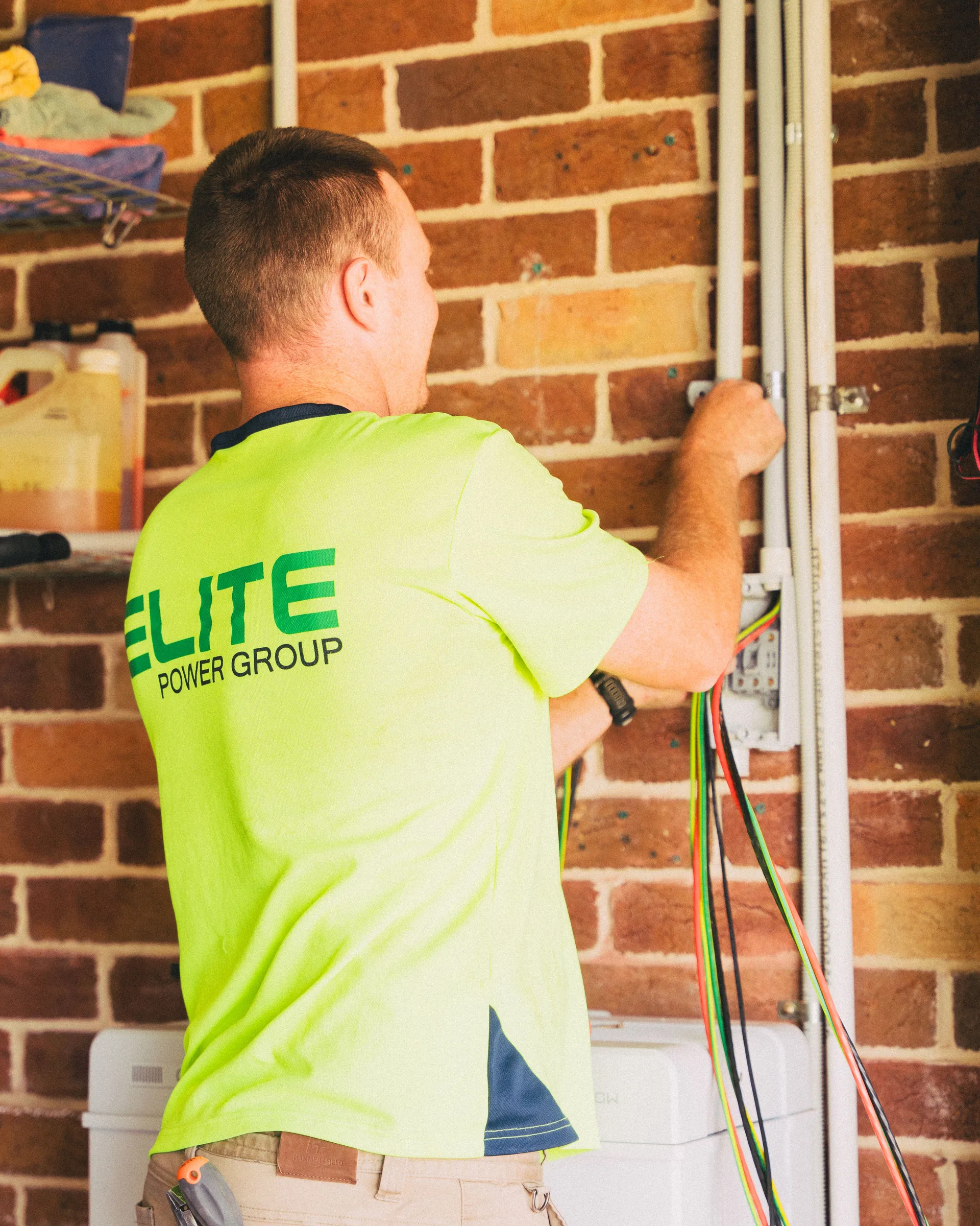 A technician working on electrical cabling inside a home