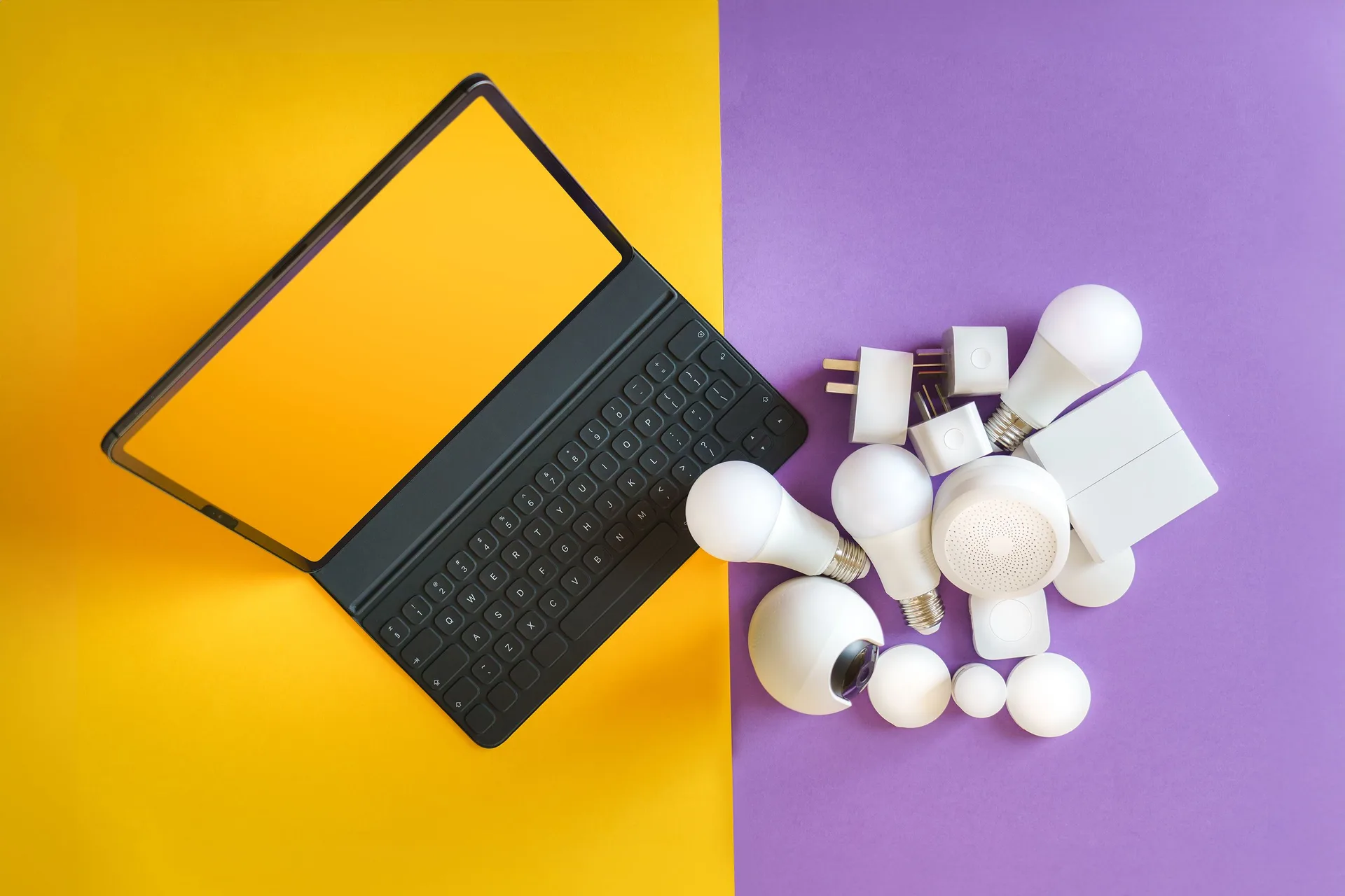 Smart home gadgets and a keyboard arranged on a colorful background