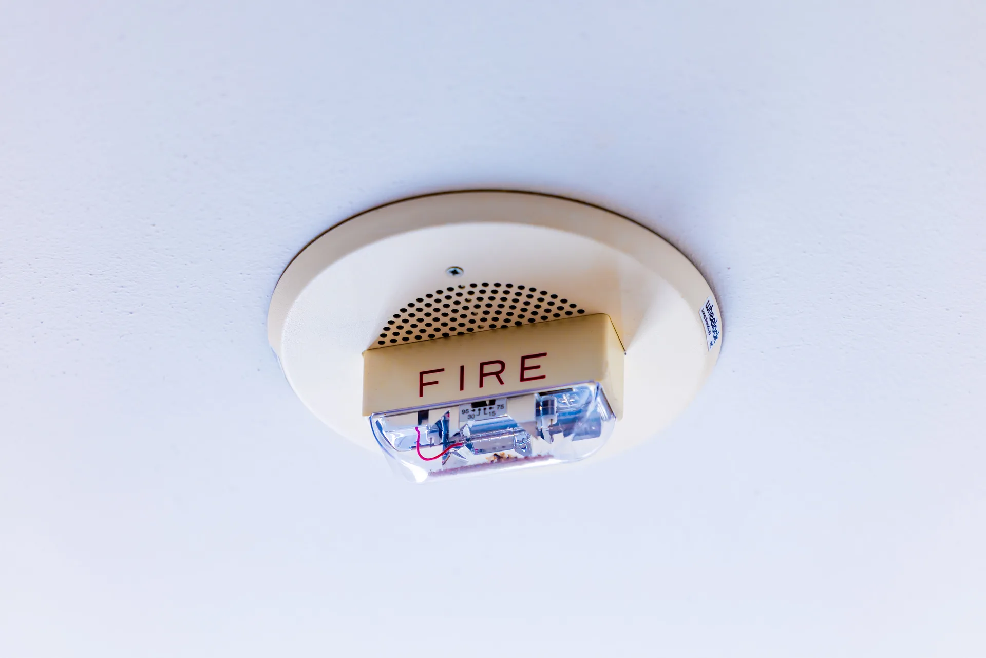 A close-up of a ceiling-mounted fire alarm