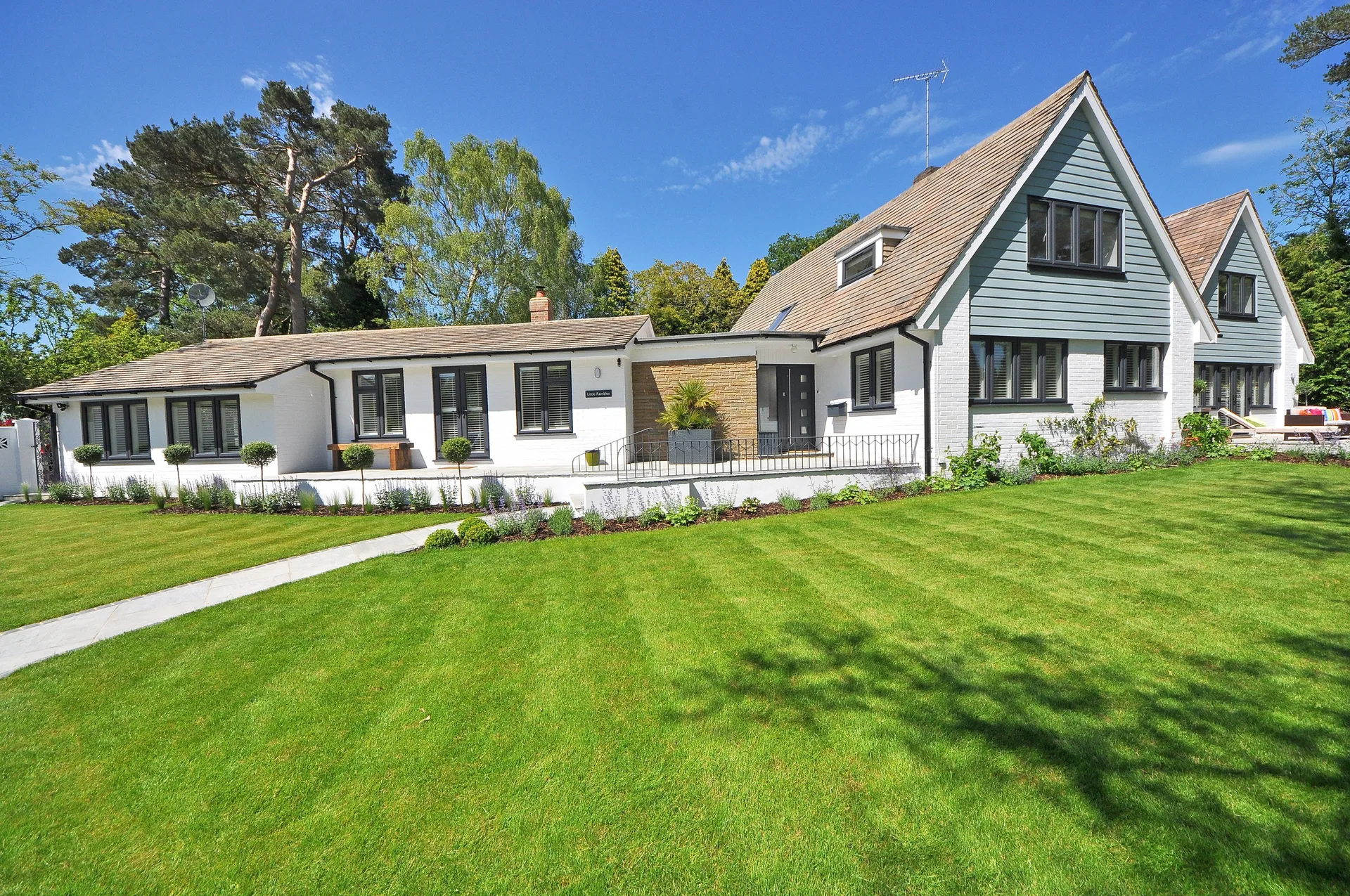 House exterior with a large manicured lawn and garden