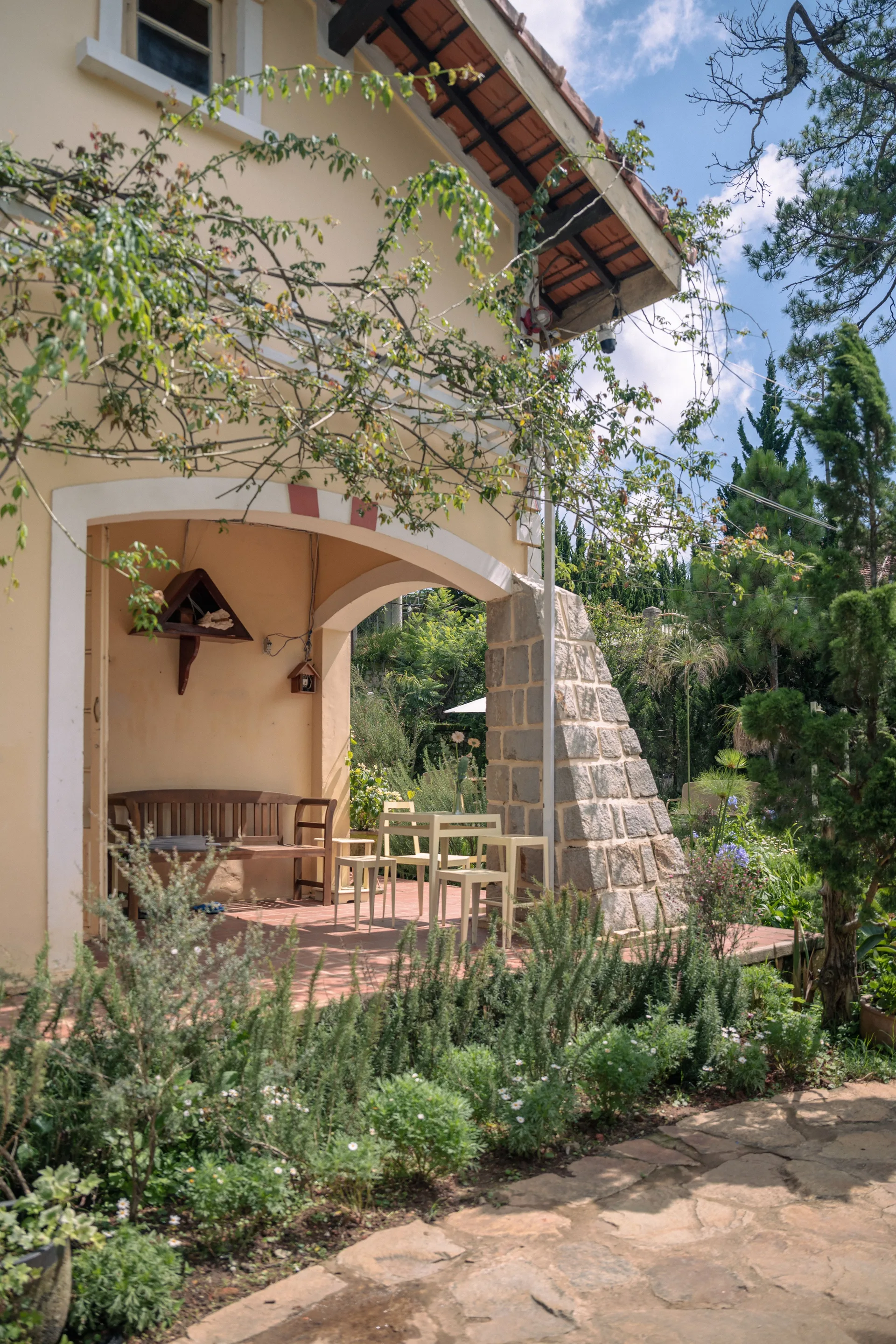 Cottage patio surrounded by greenery under a clear blue sky