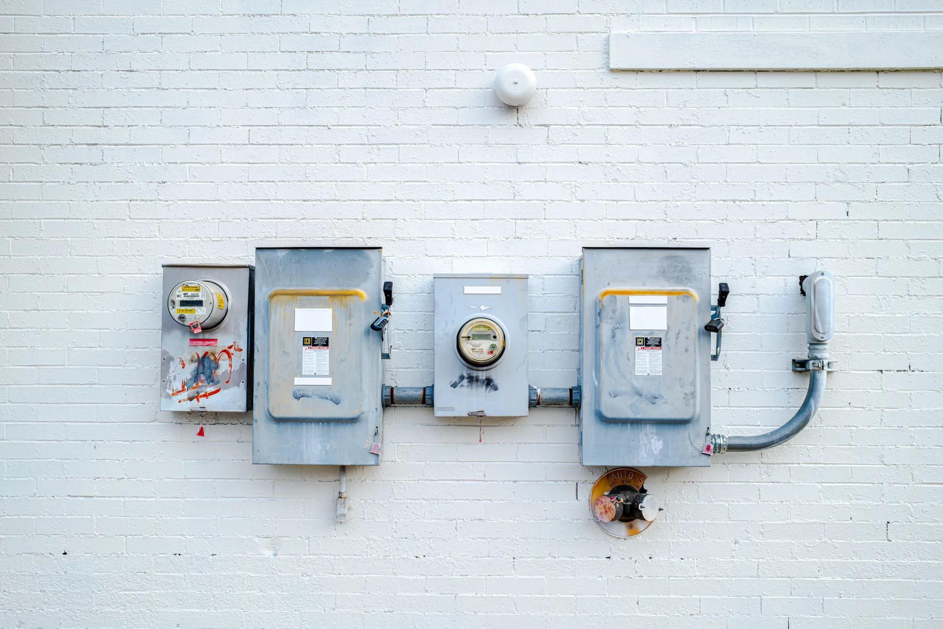 Electrical boxes and power meters mounted on a brick wall